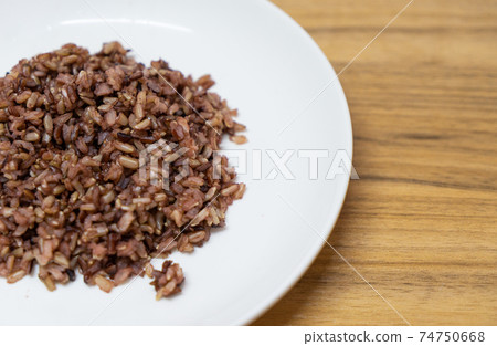 delicious brown cooked rice in white disk. 74750668