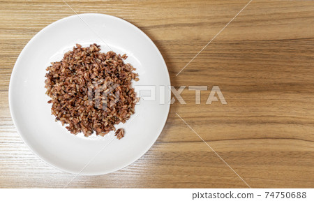 delicious brown cooked rice in white disk. delicious brown cooked rice in white disk. 74750688