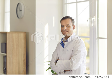 Smiling scientist or doctor in white coat standing arms crossed in laboratory or hospital Smiling scientist or doctor in white coat standing arms crossed in laboratory or hospital 74752641