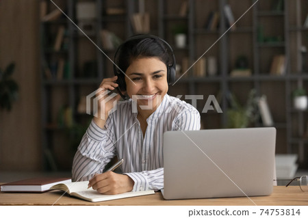 Smiling Indian female study on webcam on laptop 74753814