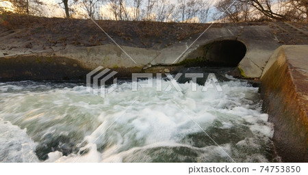 Large sewage tunnel with filth flowing out 74753850