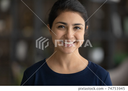 Headshot portrait of smiling young Indian woman posing 74753945