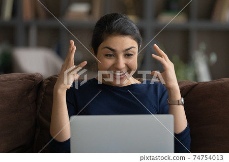 Excited Indian woman shocked by unbelievable news online 74754013