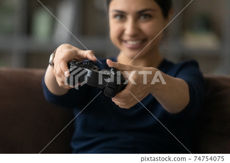 Happy Indian woman play video games with gamepad Happy Indian woman play video games with gamepad 74754075