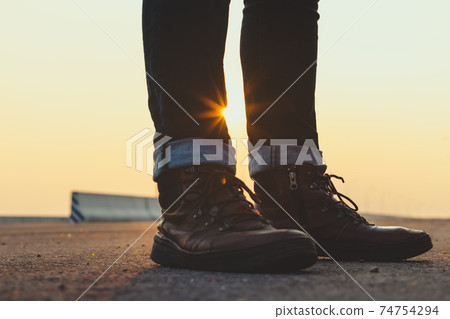 Low Section Of Man Standing On Road 74754294