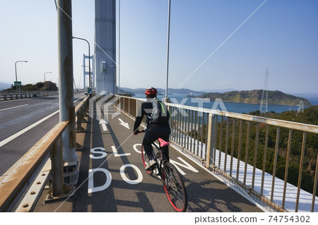 People who enjoy cycling in the beautiful Seto Inland Sea National cycle route "Shimanami Kaido Cycling Road" 74754302