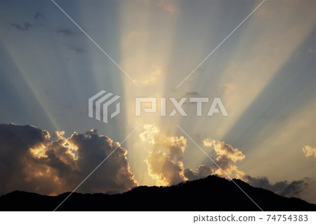 As the sun went down, a mysterious three-strand light stood like the advent of God. 74754383
