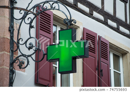 Closeup of green pharmacy signage on stoned building facade in the street 74755693