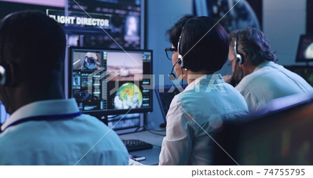 Multiracial operators working in flight control center 74755795