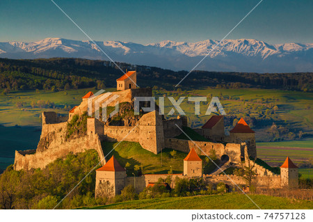Rupea fortress at sunrise and snowy mountains in background, Romania Rupea fortress at sunrise and snowy mountains in background, Romania 74757128