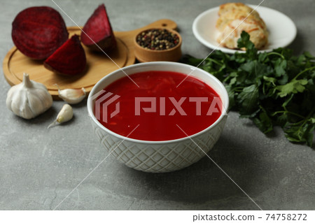 Concept of tasty eating with borscht and ingredients on gray table Concept of tasty eating with borscht and ingredients on gray table 74758272