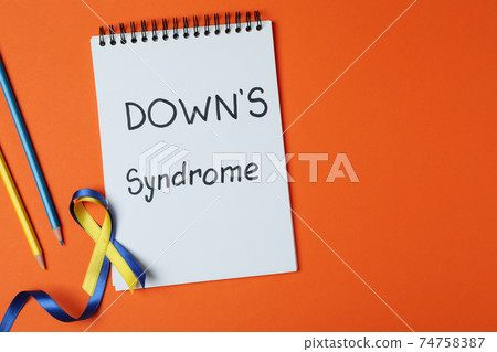 Text Down's syndrome, awareness ribbons and pencils on orange background 74758387