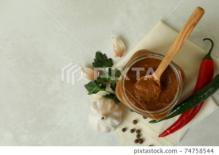 Jar with zucchini caviar on white textured table Jar with zucchini caviar on white textured table 74758544