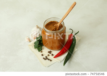 Jar with zucchini caviar on white textured table Jar with zucchini caviar on white textured table 74758546