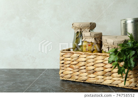 Basket with pickled food and ingredients on black smokey table 74758552