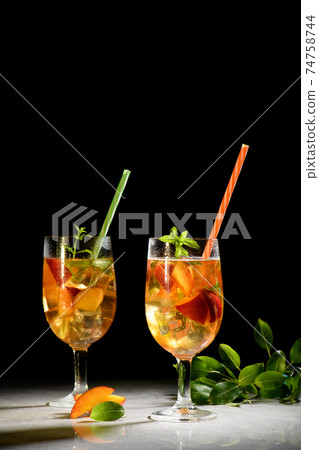 Peach fresh tea with ice, peach summer mocktail on a black background 74758744