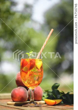 Fresh Homemade Peach Tea with Mint and Peach Slices, cold fruit drink outdoors 74758746