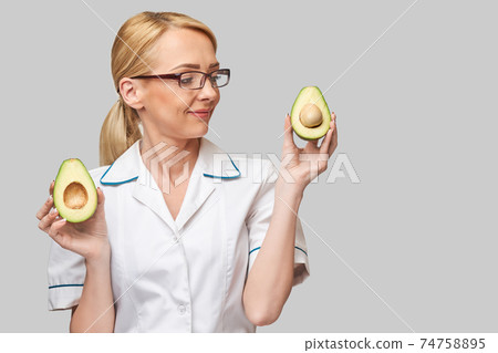 nutritionist doctor healthy lifestyle concept - holding organic avocado fruit nutritionist doctor healthy lifestyle concept - holding organic avocado fruit 74758895