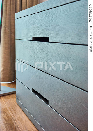 Modern wooden chest of drawers of finger pull design closeup Modern wooden chest of drawers of finger pull design closeup 74759049