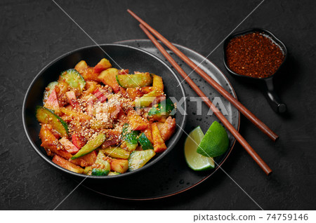 Penang Rojak in black bowl on dark slate table top. Malaysian cuisine fruits vegetables salad dish Penang Rojak in black bowl on dark slate table top. Malaysian cuisine fruits vegetables salad dish 74759146