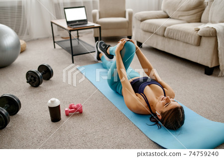 Smiling girl sits on floor, online fit training 74759240