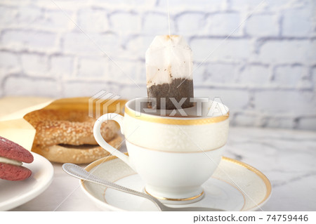 green tea with tea bag on tiles background green tea with tea bag on tiles background 74759446