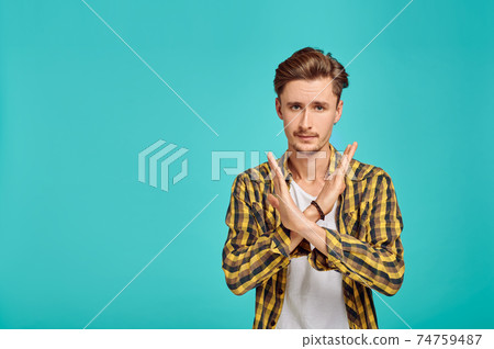 Serious man with crossed hands, blue background Serious man with crossed hands, blue background 74759487
