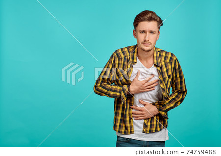 Young sick man portrait, blue background, emotion Young sick man portrait, blue background, emotion 74759488