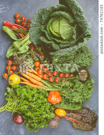 Variety of organic vegetables on blue table Variety of organic vegetables on blue table 74762185