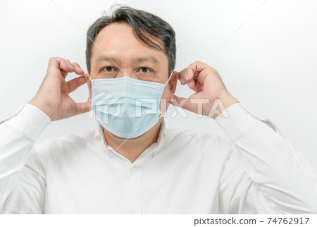 portrait of asian man in white shirt wearing face medical mask for protection from virus disease 74762917