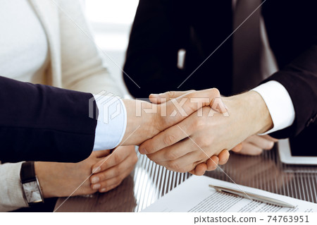 Business people shaking hands after contract signing in modern office. Teamwork, partnership and handshake concept Business people shaking hands after contract signing in modern office. Teamwork, partnership and handshake concept 74763951