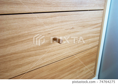Wooden drawers with wooden cylindrical handles close view 74764275