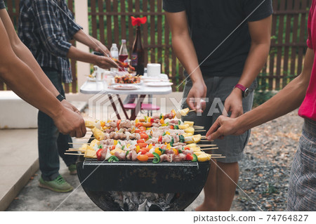 Men grilling pork and barbecue in dinner party. Food, people and family time concept. 74764827