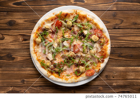 Pizza with bacon, chicken, mushrooms, arugula, tomatoes and mozzarella cheese Pizza with bacon, chicken, mushrooms, arugula, tomatoes and mozzarella cheese 74765011