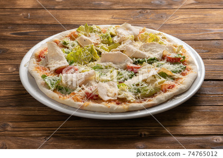 Caesar pizza with chicken breast, lettuce, cherry tomatoes and Parmesan cheese. Caesar pizza with chicken breast, lettuce, cherry tomatoes and Parmesan cheese. 74765012