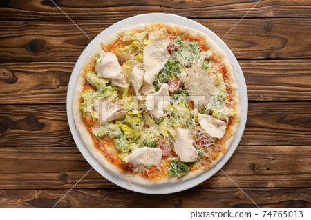 Caesar pizza with chicken breast, lettuce, cherry tomatoes and Parmesan cheese. Caesar pizza with chicken breast, lettuce, cherry tomatoes and Parmesan cheese. 74765013