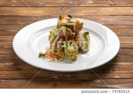 Chicken fillet rolls wrapped in bacon with avocado and vegetable filling 74765015