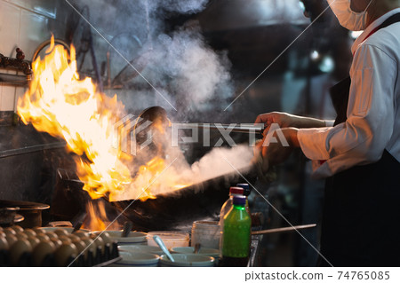 Chef stirring cooking 74765085