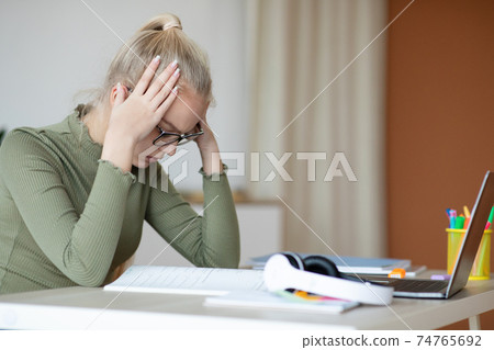 Upset schooler teen girl suffering from difficulties in home education 74765692