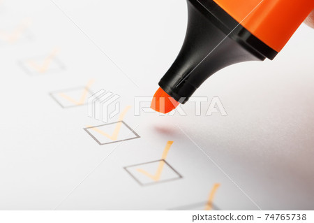 Orange marker with markers on the checklist sheet. Orange marker with markers on the checklist sheet. 74765738