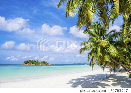 Single tropical island with blue sky and turquoise water, Seychelles Single tropical island with blue sky and turquoise water, Seychelles 74765947