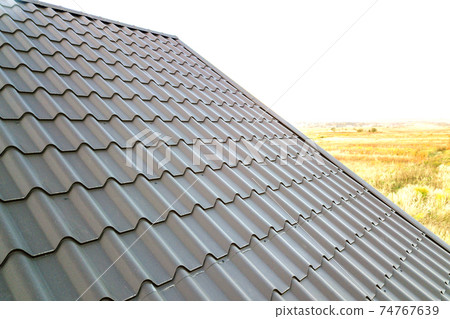 Close up of new house roof structure covered with metal tile sheets. 74767639