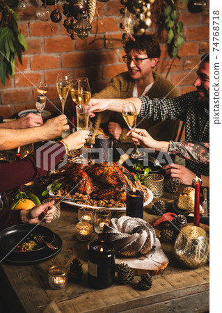 People clinking glasses over Christmas festive People clinking glasses over Christmas festive 74768718