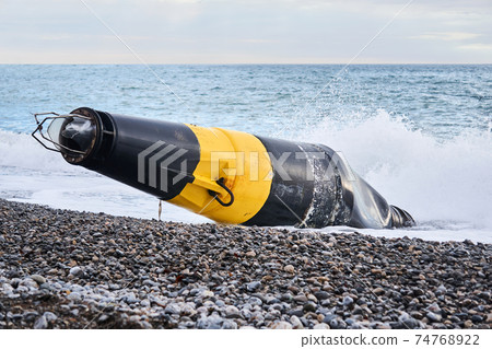 damaged sea buoy (cardinal danger mark) washed ashore after a storm damaged sea buoy (cardinal danger mark) washed ashore after a storm 74768922