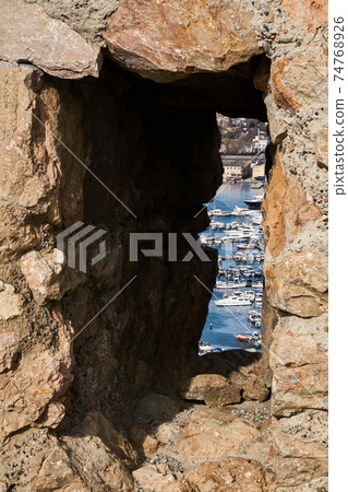 view of the modern harbor through the loophole of the old fortress view of the modern harbor through the loophole of the old fortress 74768926