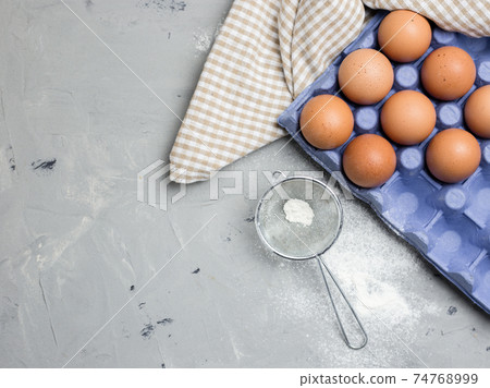 Ingredients for pastries: flour, eggs on light gray background, top view, copy space. 74768999
