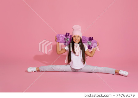 girl sitting on a transverse twine and holding skateboard girl sitting on a transverse twine and holding skateboard 74769179