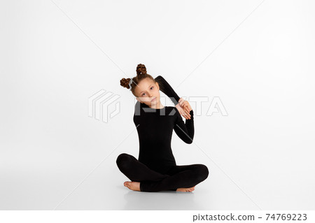 child girl in black sportswear doing stretching. child girl in black sportswear doing stretching. 74769223