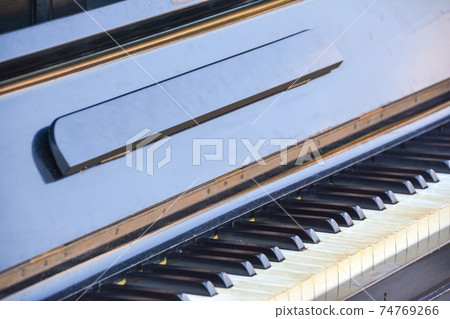 A brown wooden exposed piano, an upright piano keyboard, and a music stand installed outdoors in Hiroshima City, Hiroshima Prefecture. 74769266