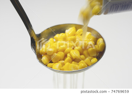 Draining canned corn with a perforated ladle Draining canned corn with a perforated ladle 74769659